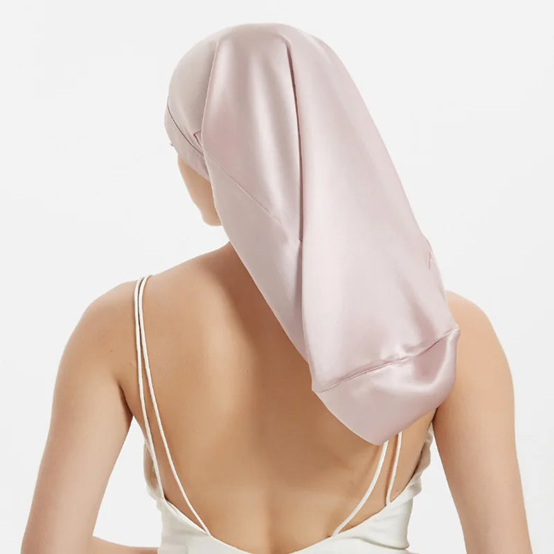 Femme portant bonnet de nuit en soie – cheveux bouclés protégés vue arriere rose