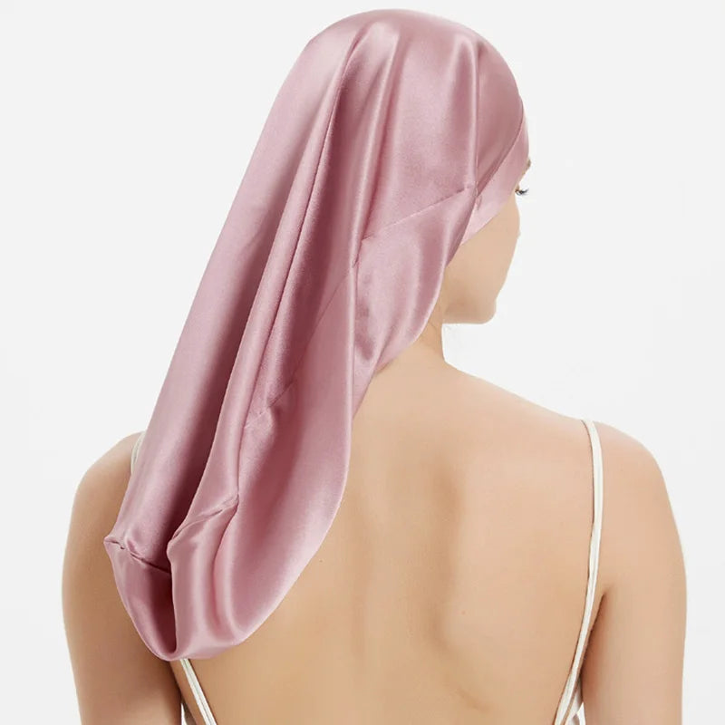 Femme portant bonnet de nuit en soie – cheveux bouclés protégés rose