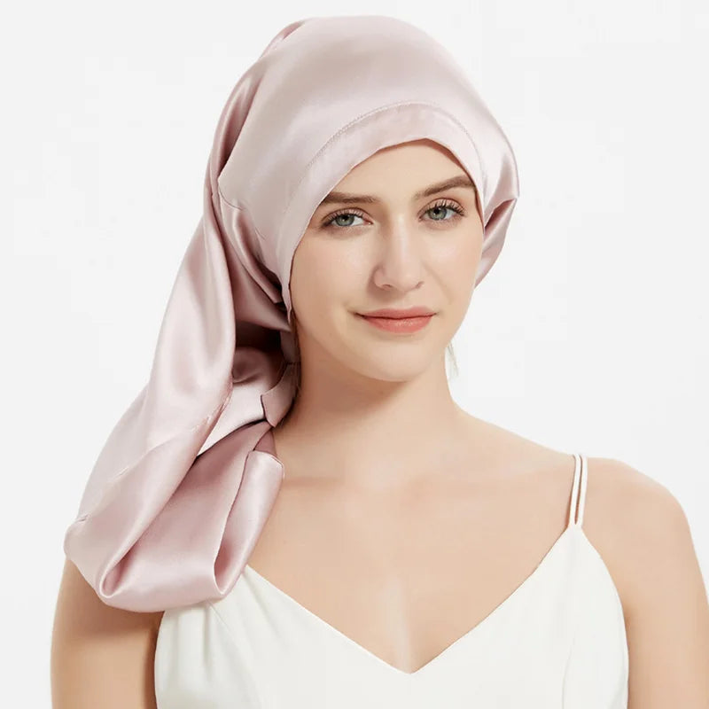 Femme portant bonnet de nuit en soie – cheveux bouclés protégés de fce rose pale