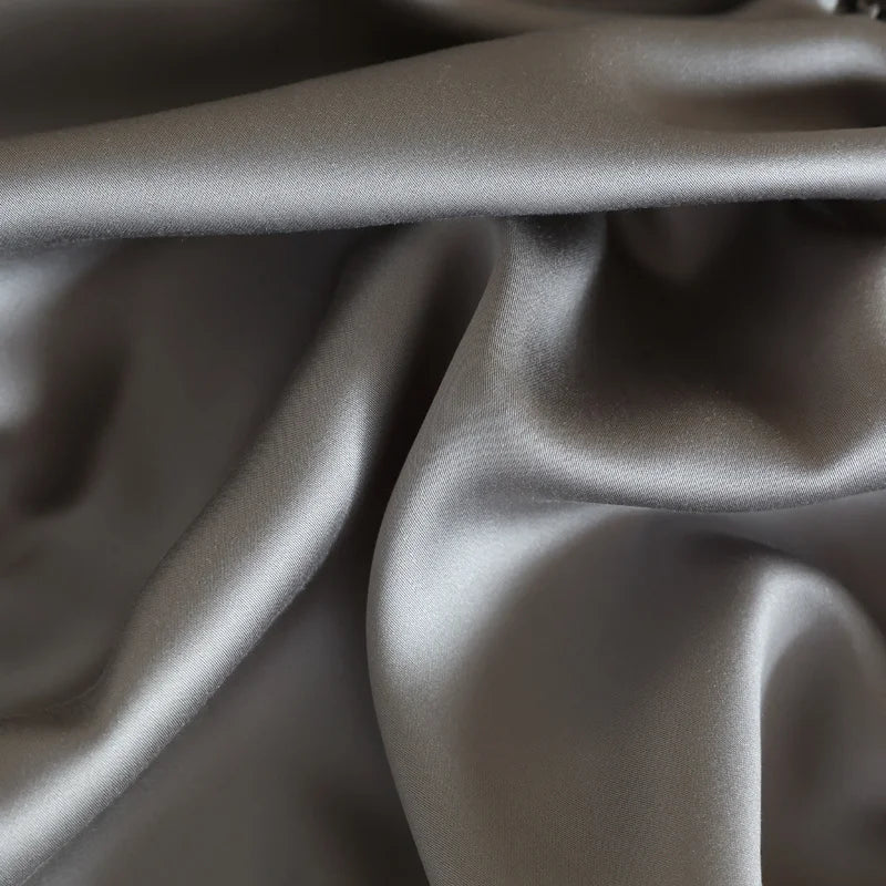 Gros plan sur la texture douce et naturelle de la soie de mûrier GRIS 