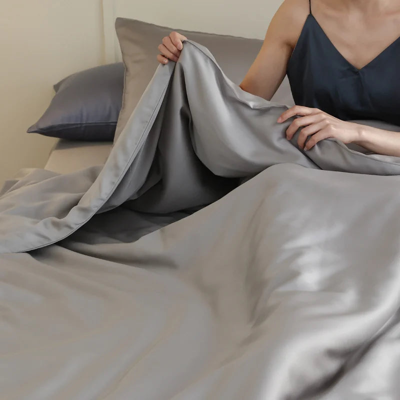 Housse de couette en soie de mûrier naturelle installée sur un lit double haut de gamme GRIS
