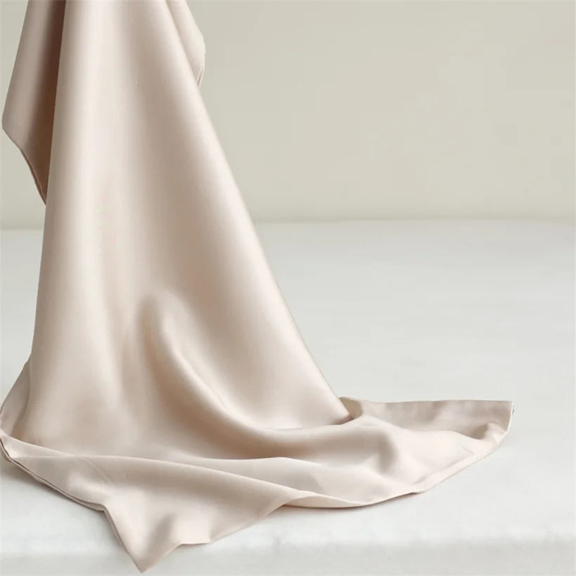 Gros plan sur le tissage soyeux de la taie d’oreiller en soie de mûrier, texture lisse et confortable